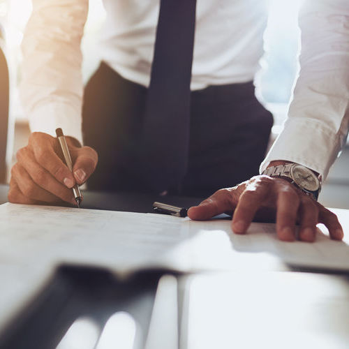 Businessman wearing a watch drawing up a budget.