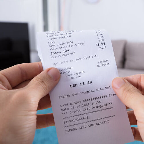 A Person Looks Over a Receipt.