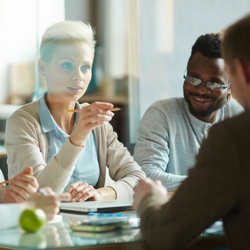 Young Female White Collar Worker Teaching Male Colleagues